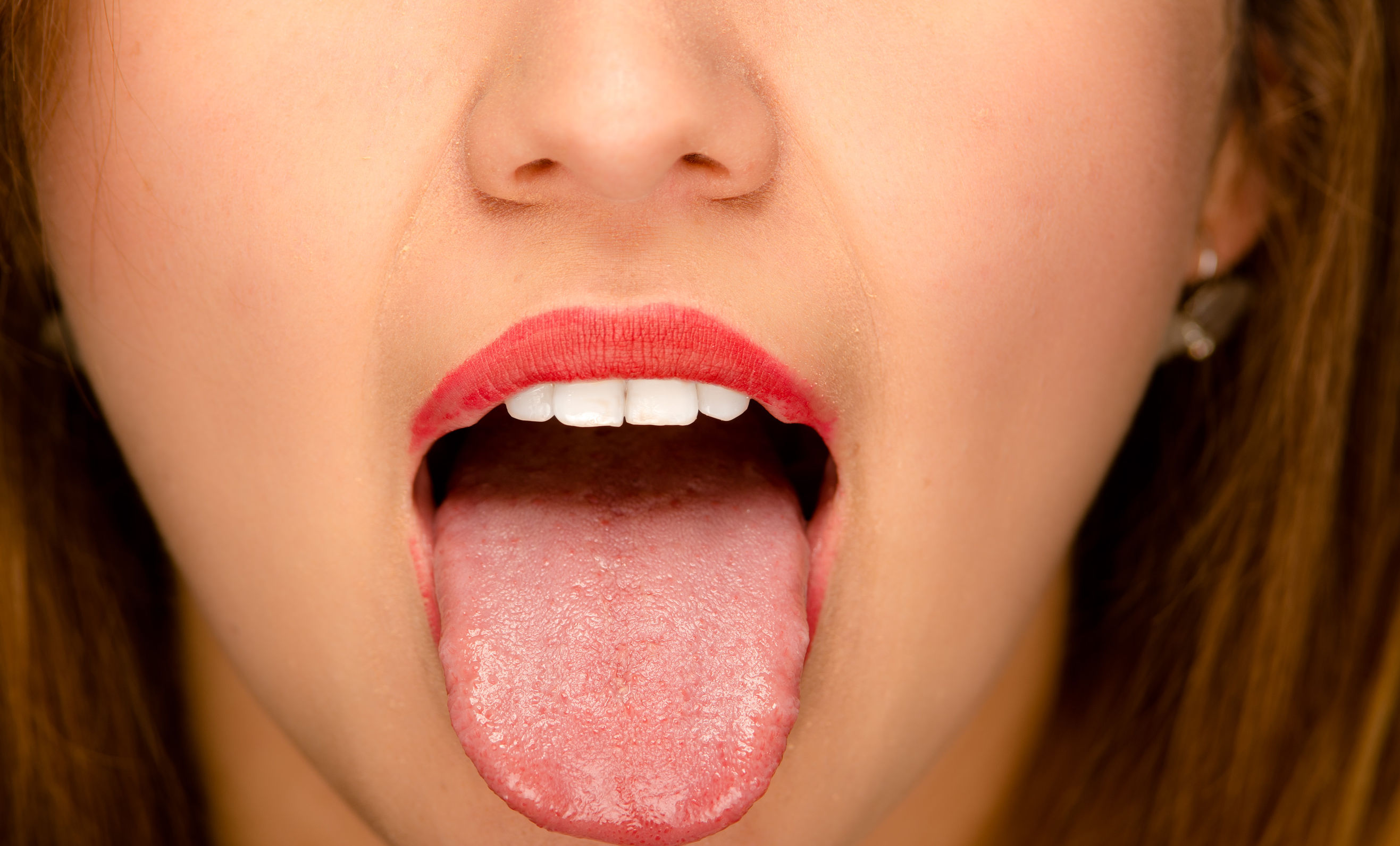 55226600 Closeup Young Womans Open Mouth With Tongue Sticking Out 